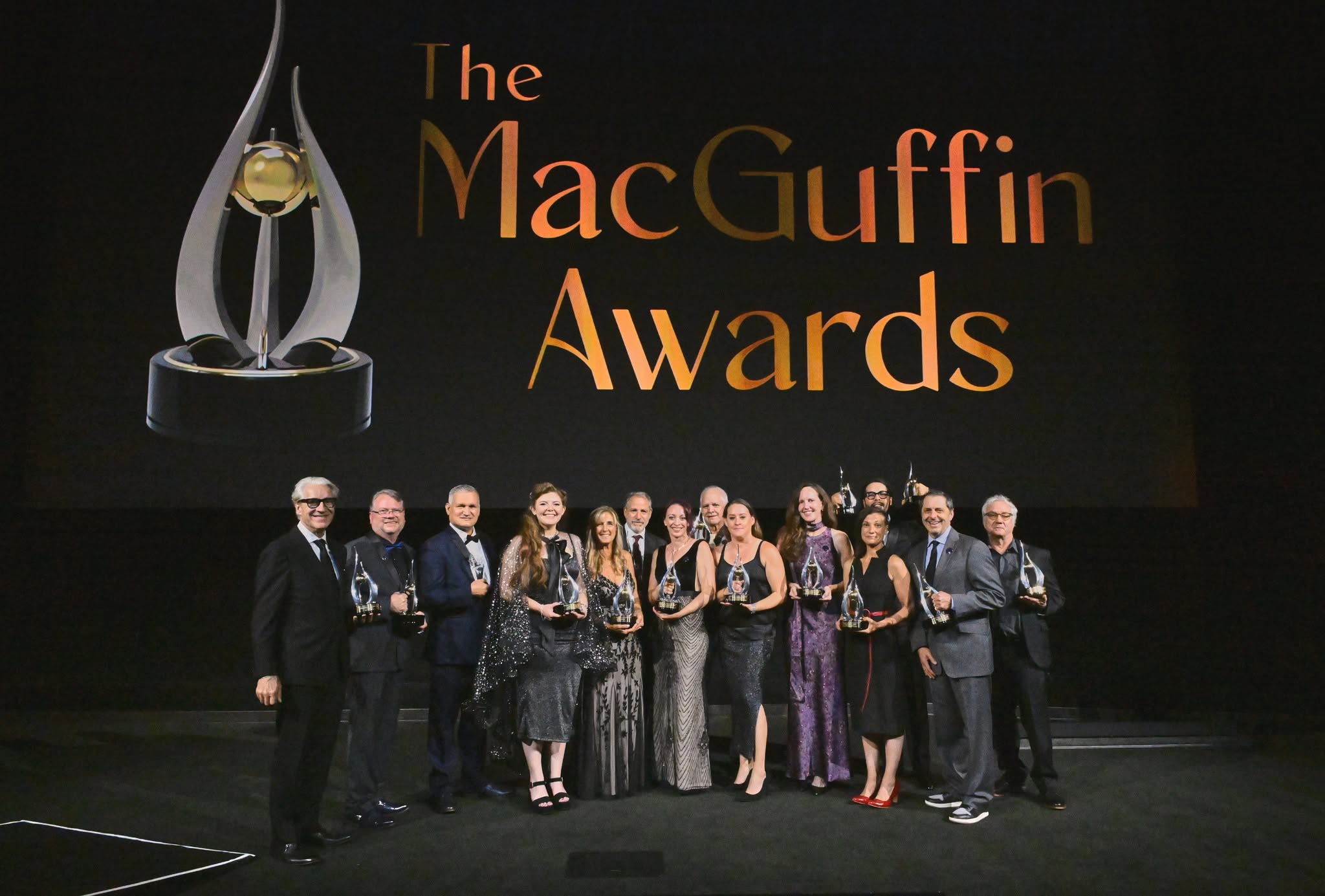 2026 MacGuffin Awards recipients pose with their trophies onstage beneath the awards title.