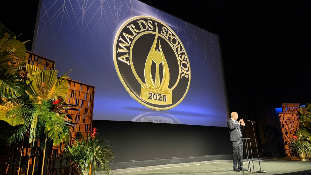 Property Masters Guild president Jeffrey Johnson speaks beside the 2026 Awards Sponsor pin displayed onstage.